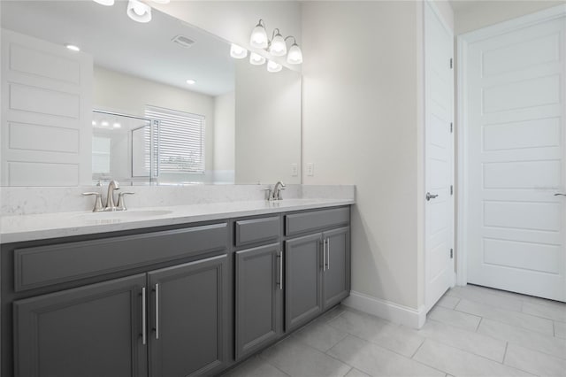 bathroom with a shower with shower door, vanity, and tile patterned flooring