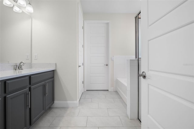 bathroom featuring a tub to relax in, vanity, and tile patterned flooring