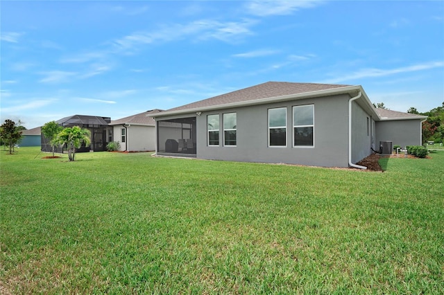 back of property featuring a sunroom, a lawn, and central AC