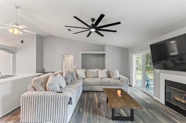 living room featuring lofted ceiling, dark wood-type flooring, and ceiling fan