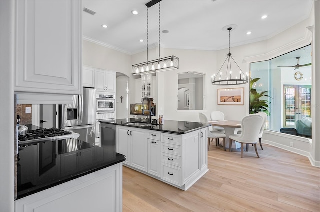 kitchen featuring decorative light fixtures, sink, white cabinets, and stainless steel appliances