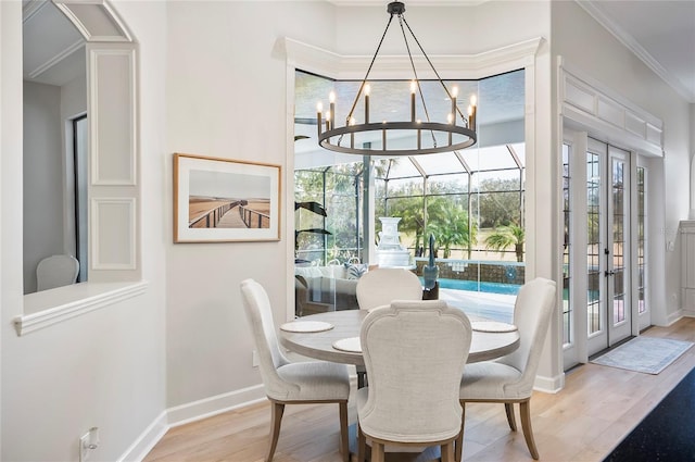 dining area featuring light hardwood / wood-style flooring, ornamental molding, and a chandelier