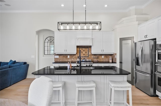 kitchen with appliances with stainless steel finishes, an island with sink, and a breakfast bar area