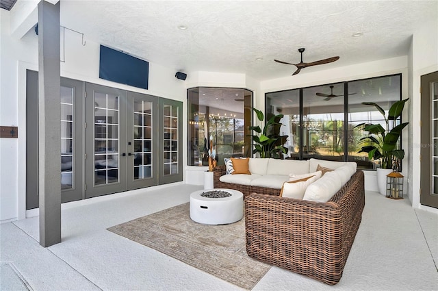 living room with ceiling fan, french doors, and a textured ceiling