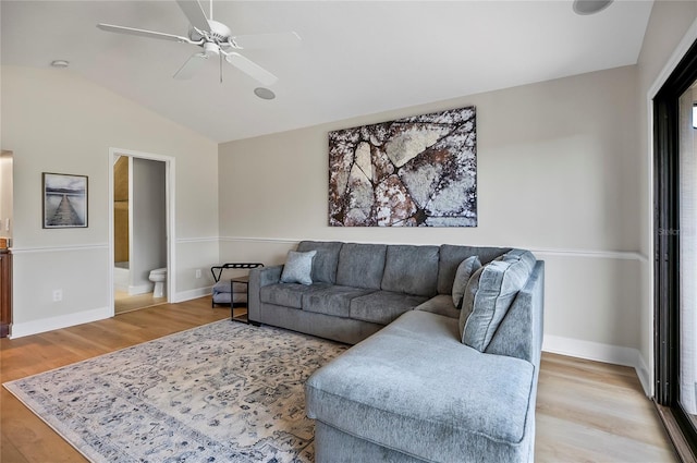 living room featuring vaulted ceiling, ceiling fan, and light hardwood / wood-style flooring