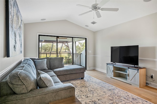 living room featuring hardwood / wood-style flooring, ceiling fan, and vaulted ceiling