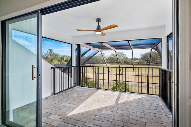 unfurnished sunroom featuring ceiling fan