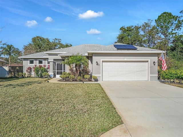 ranch-style house with a garage, a front yard, and solar panels