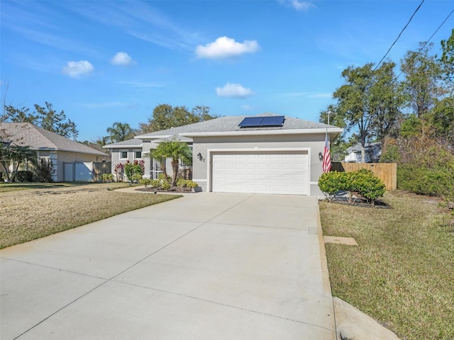 view of front facade with a garage, a front lawn, and solar panels