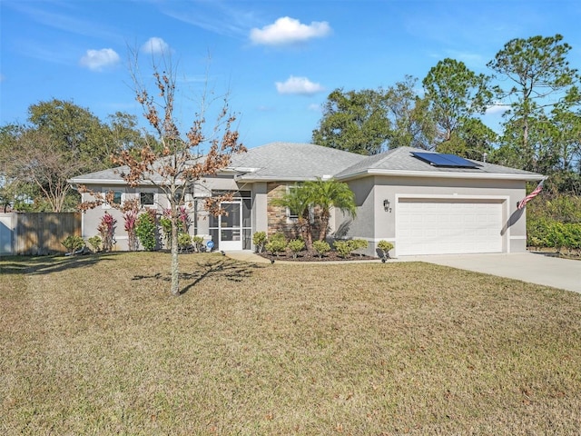 single story home featuring a garage, a front yard, and solar panels