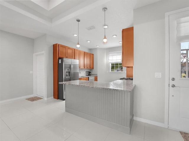 kitchen featuring light stone counters, light tile patterned floors, kitchen peninsula, pendant lighting, and stainless steel appliances