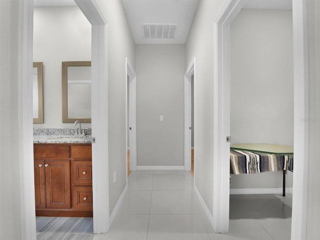 hallway featuring light tile patterned flooring and sink