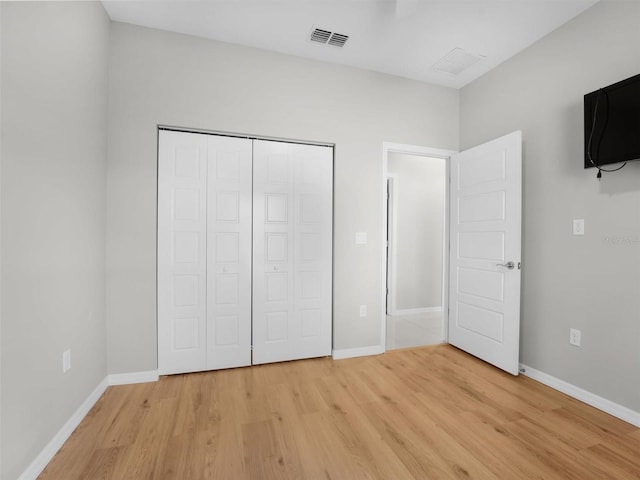 unfurnished bedroom with light hardwood / wood-style floors and a closet