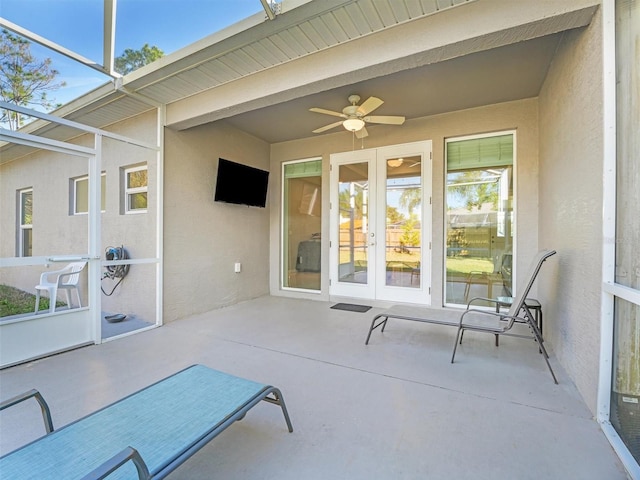 sunroom / solarium featuring a wealth of natural light, ceiling fan, and french doors