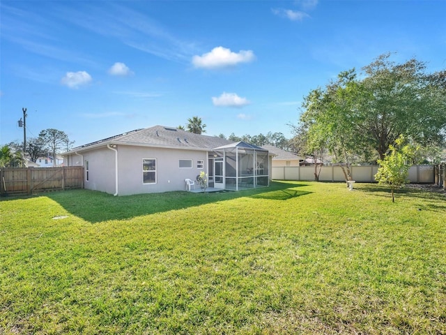 back of property featuring glass enclosure and a lawn