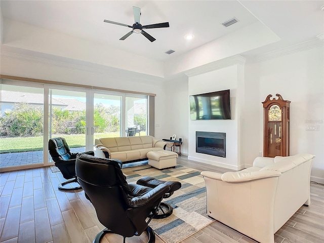 living room featuring ceiling fan and a tray ceiling