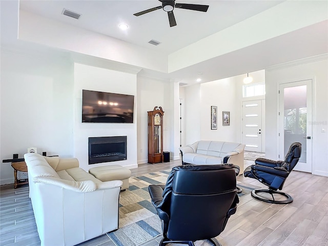 living room with ceiling fan and a tray ceiling