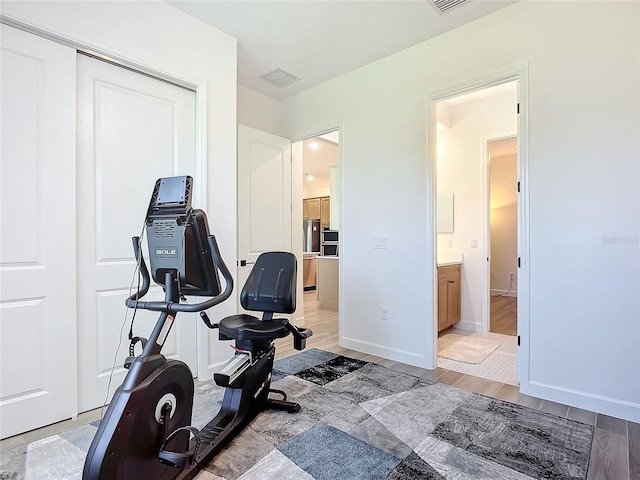 exercise room with light wood-type flooring