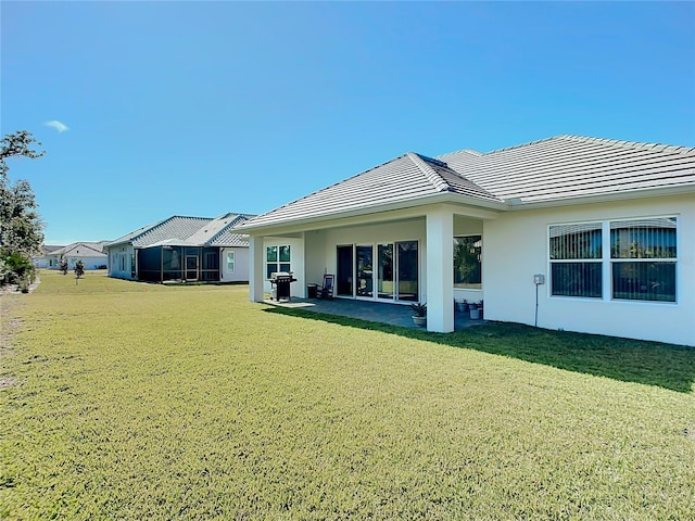 back of house featuring a lawn and a patio