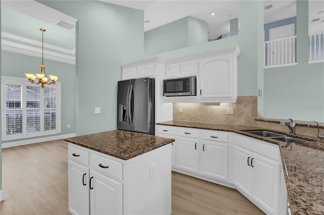 kitchen with stainless steel appliances, dark stone countertops, white cabinets, and sink