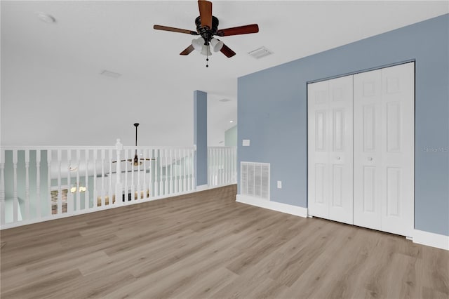 unfurnished bedroom featuring light wood-type flooring, ceiling fan, and a closet