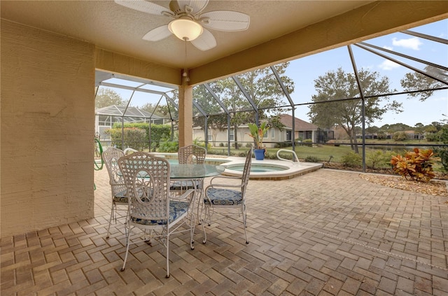 view of patio / terrace with a lanai, ceiling fan, and an in ground hot tub