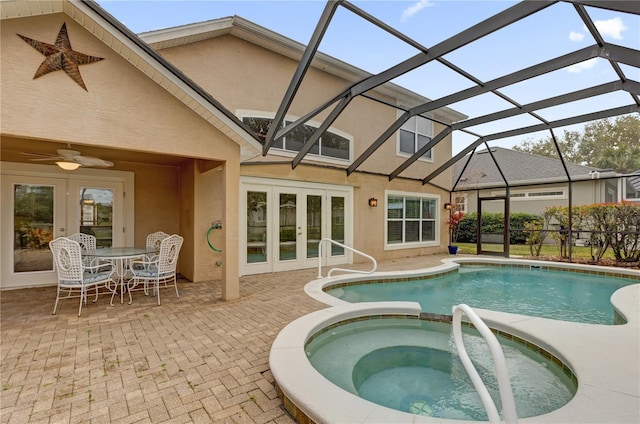 view of pool featuring glass enclosure, an in ground hot tub, a patio area, french doors, and ceiling fan