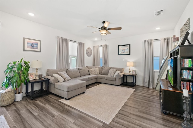 living room featuring ceiling fan and dark wood-type flooring