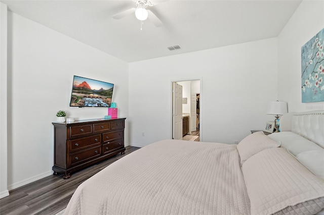 bedroom featuring ceiling fan, dark hardwood / wood-style floors, and connected bathroom