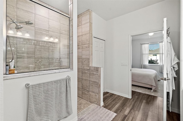 bathroom featuring wood-type flooring and a tile shower