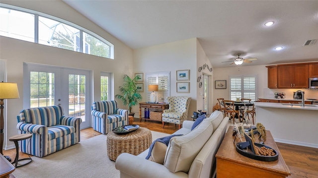 living room featuring french doors, ceiling fan, lofted ceiling, and light hardwood / wood-style flooring