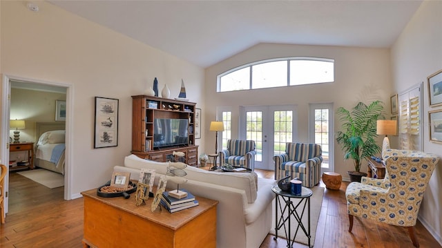 living room with french doors, wood-type flooring, and high vaulted ceiling