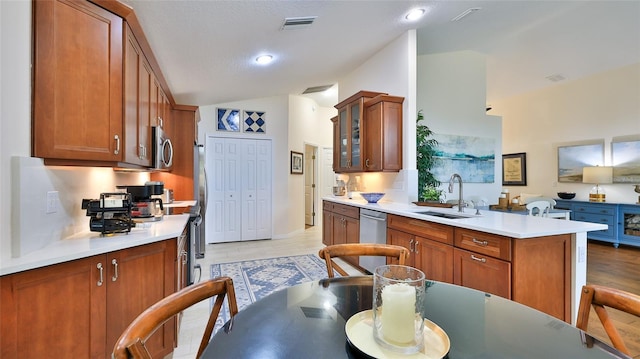 kitchen featuring light hardwood / wood-style floors, appliances with stainless steel finishes, tasteful backsplash, a textured ceiling, and sink