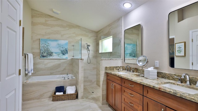 bathroom featuring lofted ceiling, vanity, a textured ceiling, and shower with separate bathtub