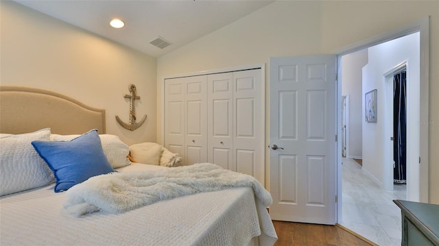 bedroom featuring a closet, lofted ceiling, and wood-type flooring