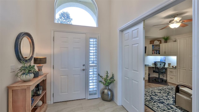 foyer entrance featuring ceiling fan and built in desk