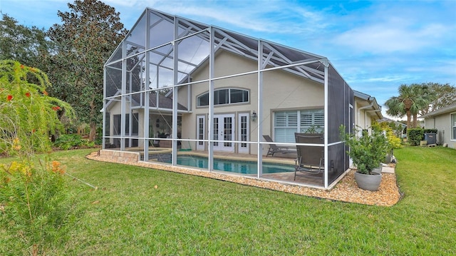 rear view of house featuring glass enclosure, a yard, french doors, and a patio