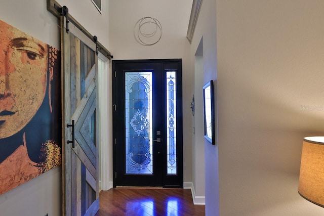 foyer entrance with dark wood-type flooring and a barn door