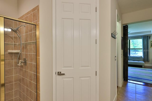 bathroom featuring tile patterned flooring and a tile shower