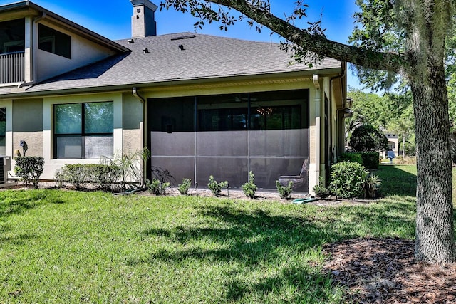 view of side of home with a sunroom and a yard