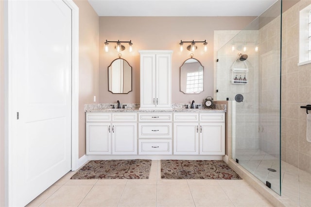 bathroom with tiled shower, vanity, and tile patterned flooring