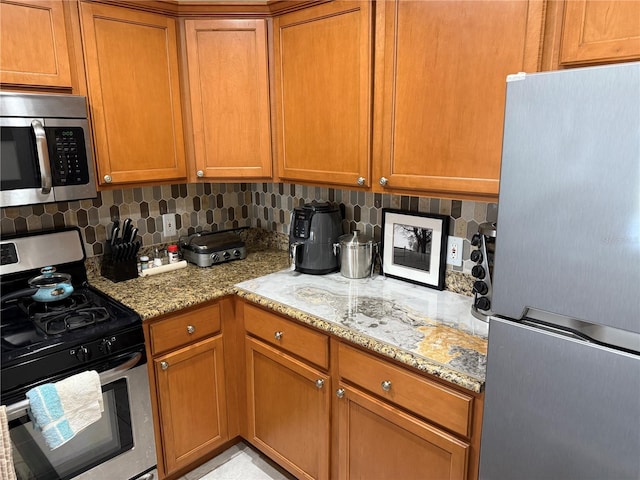 kitchen with backsplash, light stone counters, and stainless steel appliances