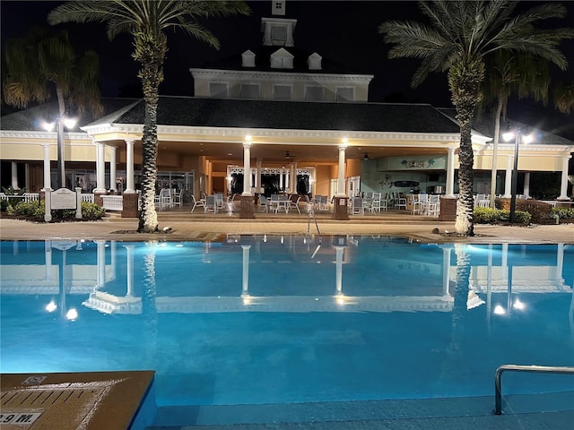 pool at night with a patio area