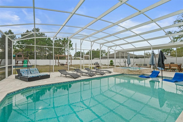 view of pool with a lanai, a playground, a patio, and an in ground hot tub