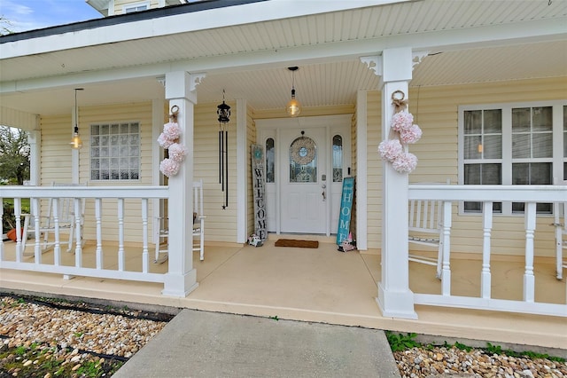 view of exterior entry featuring covered porch