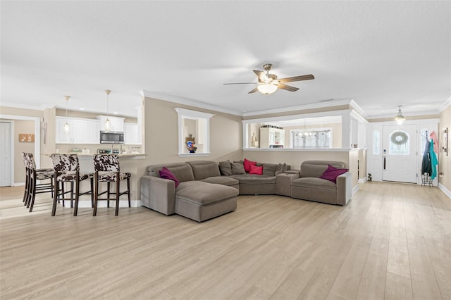 living room featuring ceiling fan, light hardwood / wood-style floors, and ornamental molding