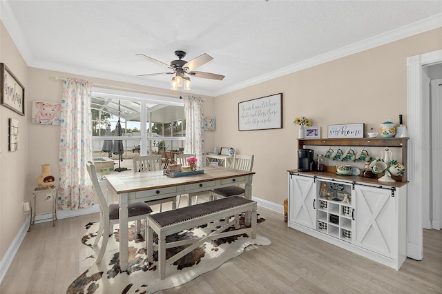 dining space featuring ceiling fan, ornamental molding, and light hardwood / wood-style flooring