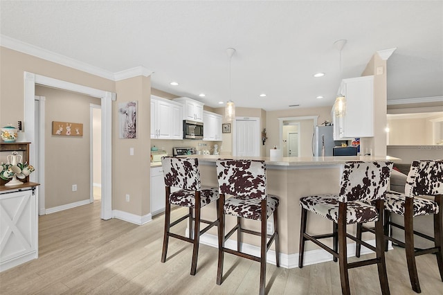 kitchen with white cabinetry, light hardwood / wood-style floors, kitchen peninsula, stainless steel appliances, and crown molding