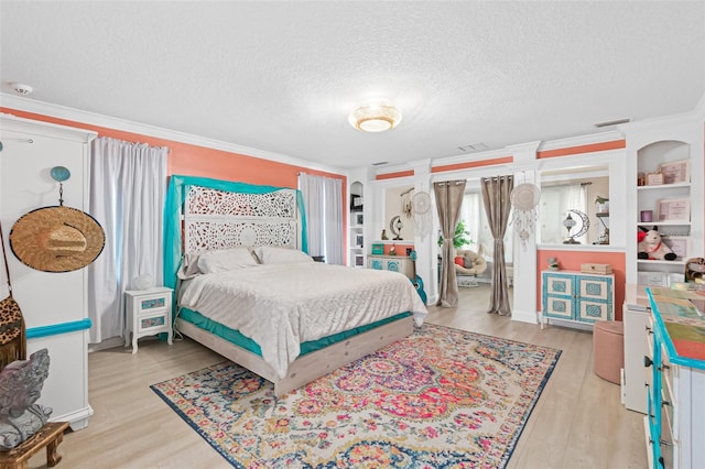 bedroom featuring light hardwood / wood-style floors, a textured ceiling, and ornamental molding