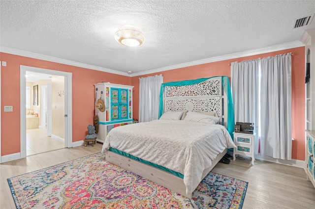 bedroom with a textured ceiling, ensuite bathroom, ornamental molding, and light hardwood / wood-style flooring